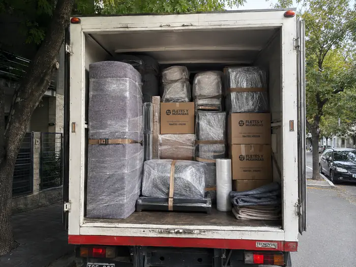 Interior del camión con muebles envueltos y cajas ordenadas