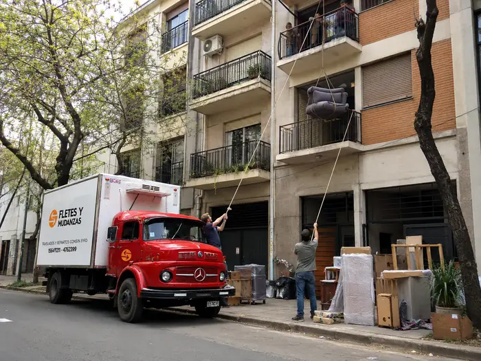 Izamiento de un sillón por el balcón con sogas y personal especializado